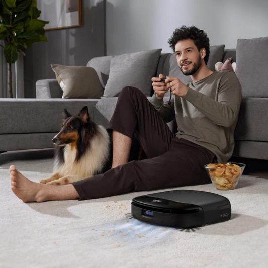 The eufy Omni S1 Pro robot vacuum cleaner vacuums the living room carpet, next to a man and his dog